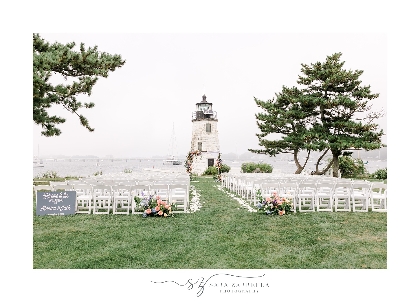 wedding ceremony on lawn in front of Newport Lighthouse with pink and peach flowers 