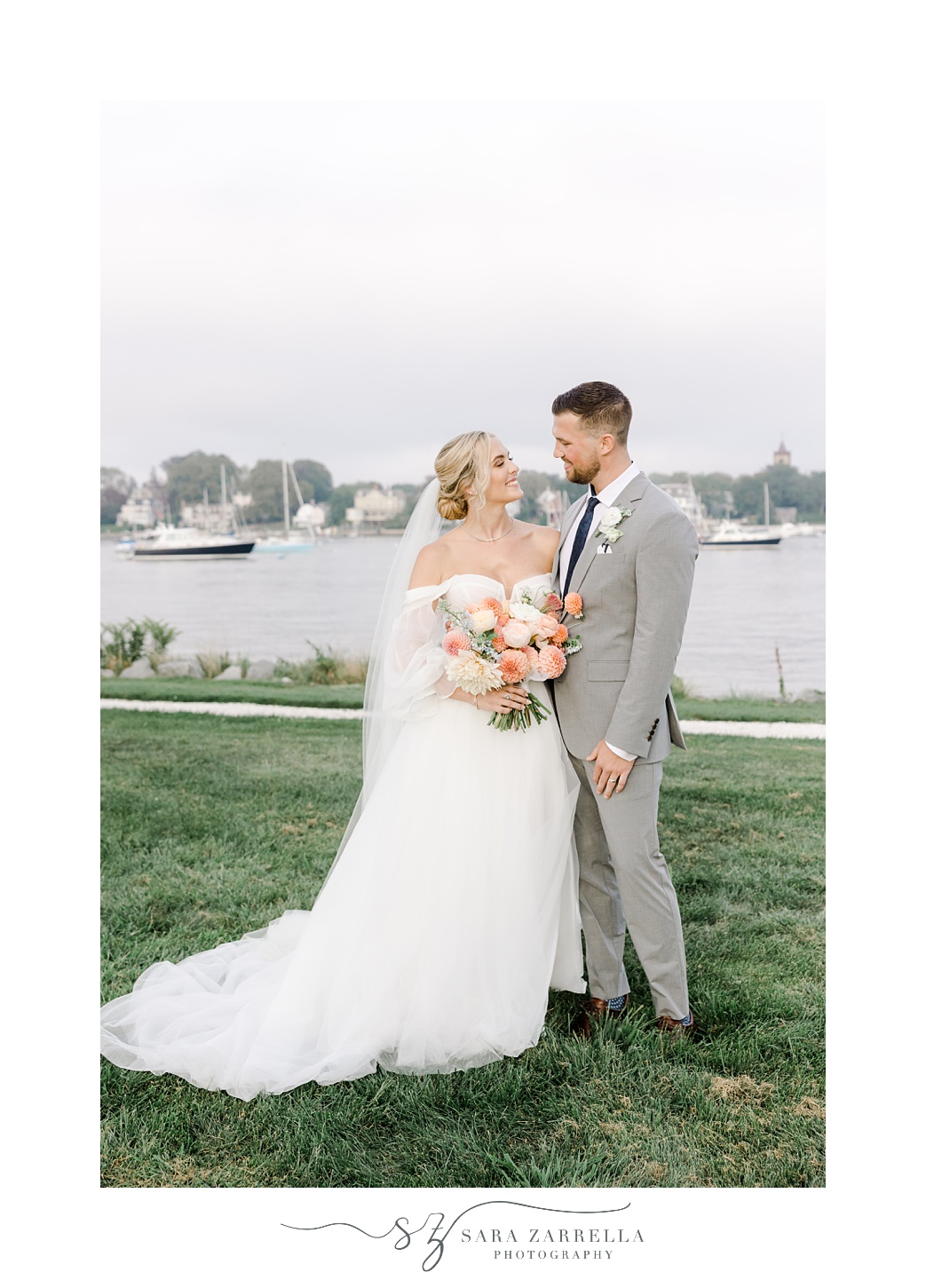 bride and groom stand on lawn outside Newport Harbor Island Resort