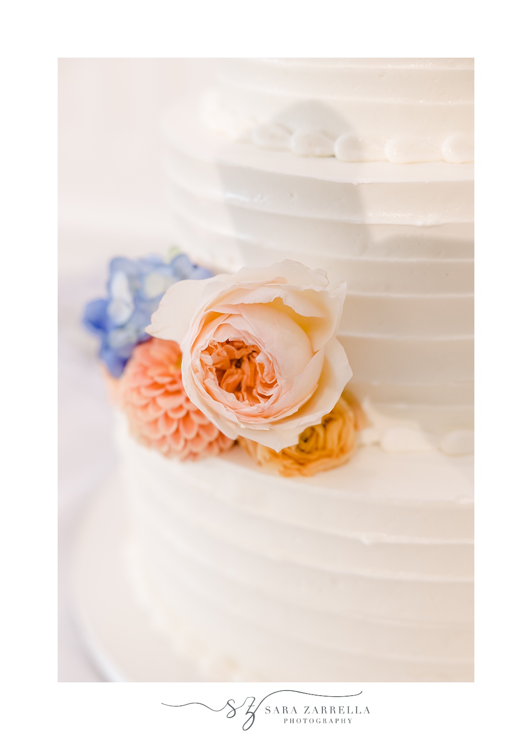 tiered wedding cake with peach rose accents 