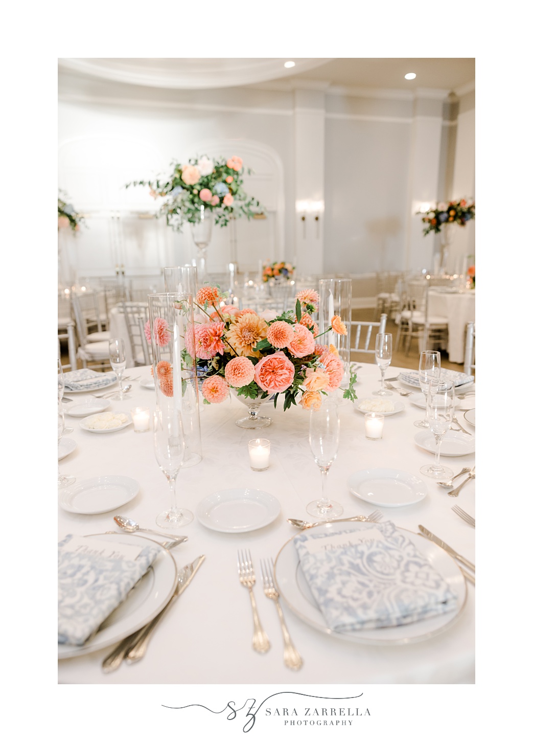 wedding reception at Newport Harbor Island Resort with peach and pink flowers and blue taper candles 