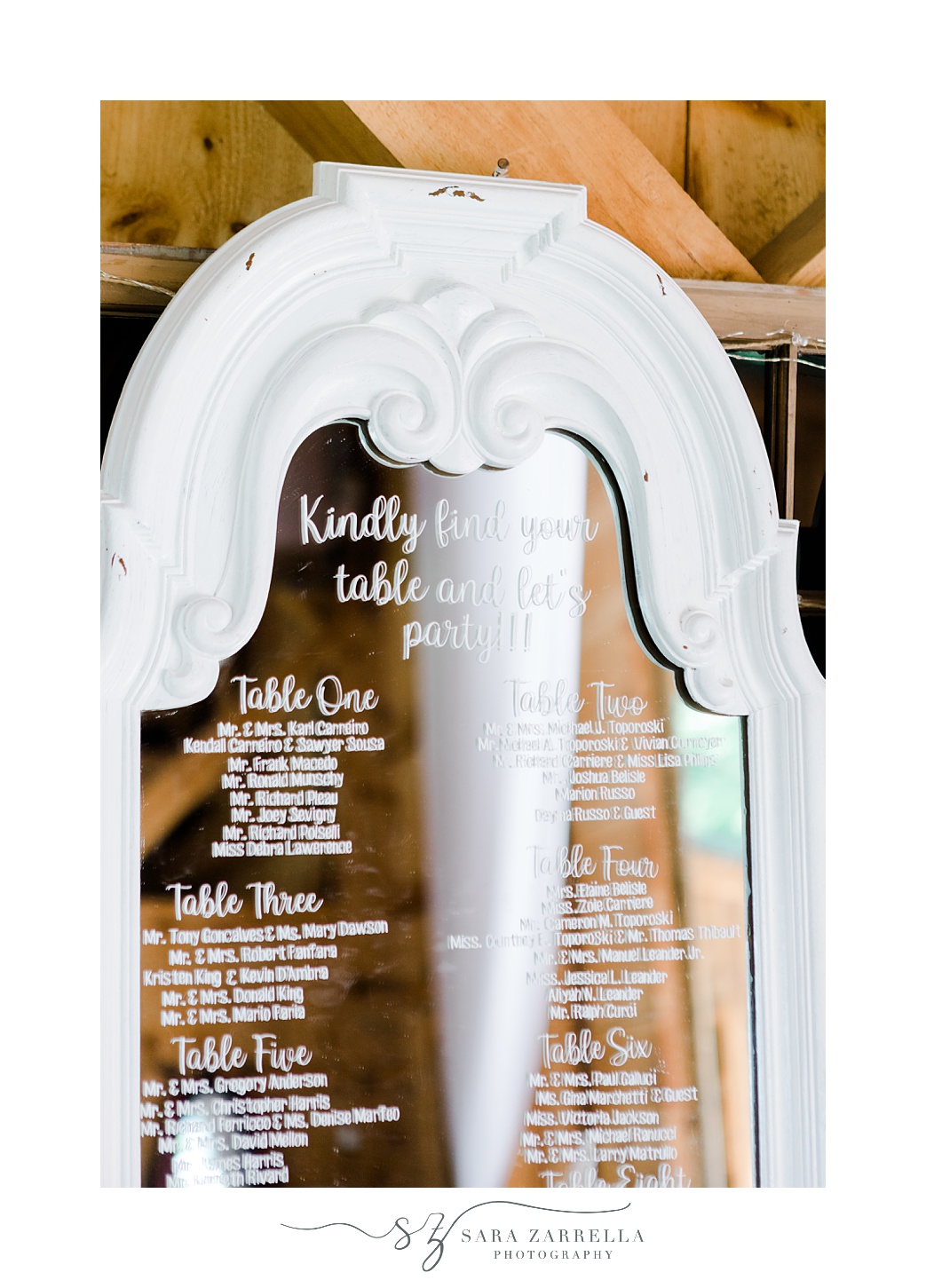 seating chart on mirror with white frame during wedding reception in the Pavilion at Blissful Meadows