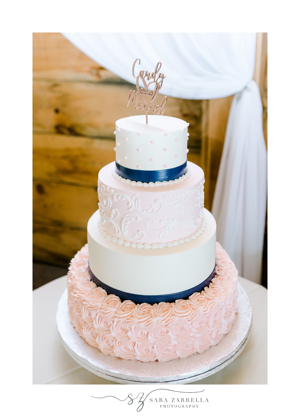 tiered wedding cake with pink icing and blue ribbon for wedding reception in the Pavilion at Blissful Meadows
