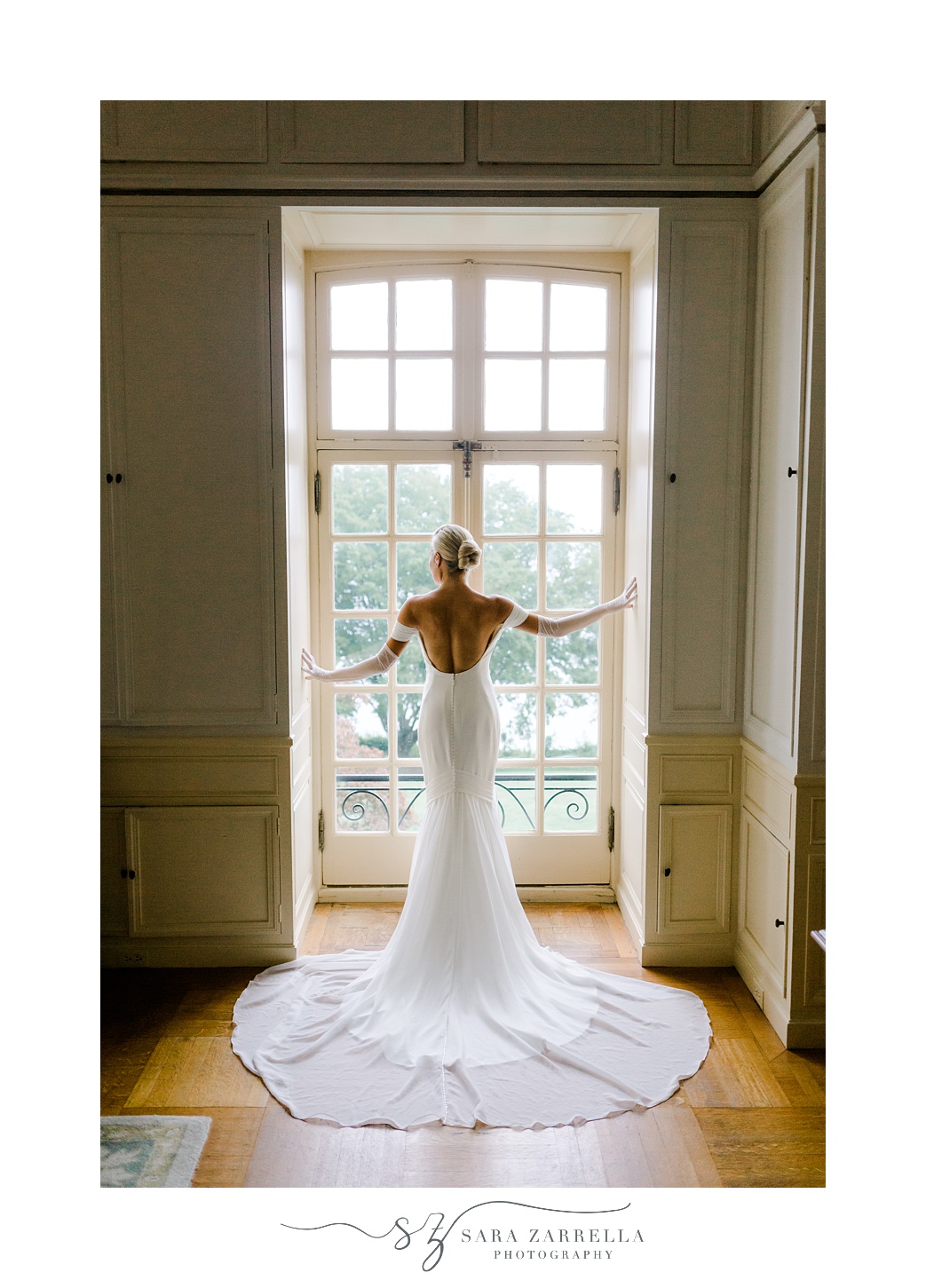 bride stands in window in wedding gown at Glen Manor House
