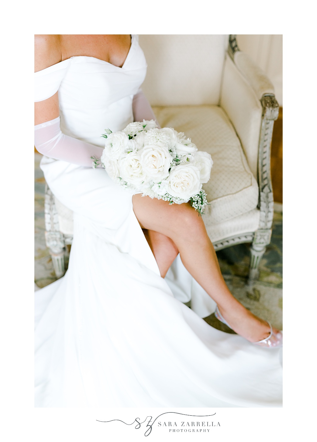 bride sits on sofa in suite at Glen Manor House showing off leg from wedding gown