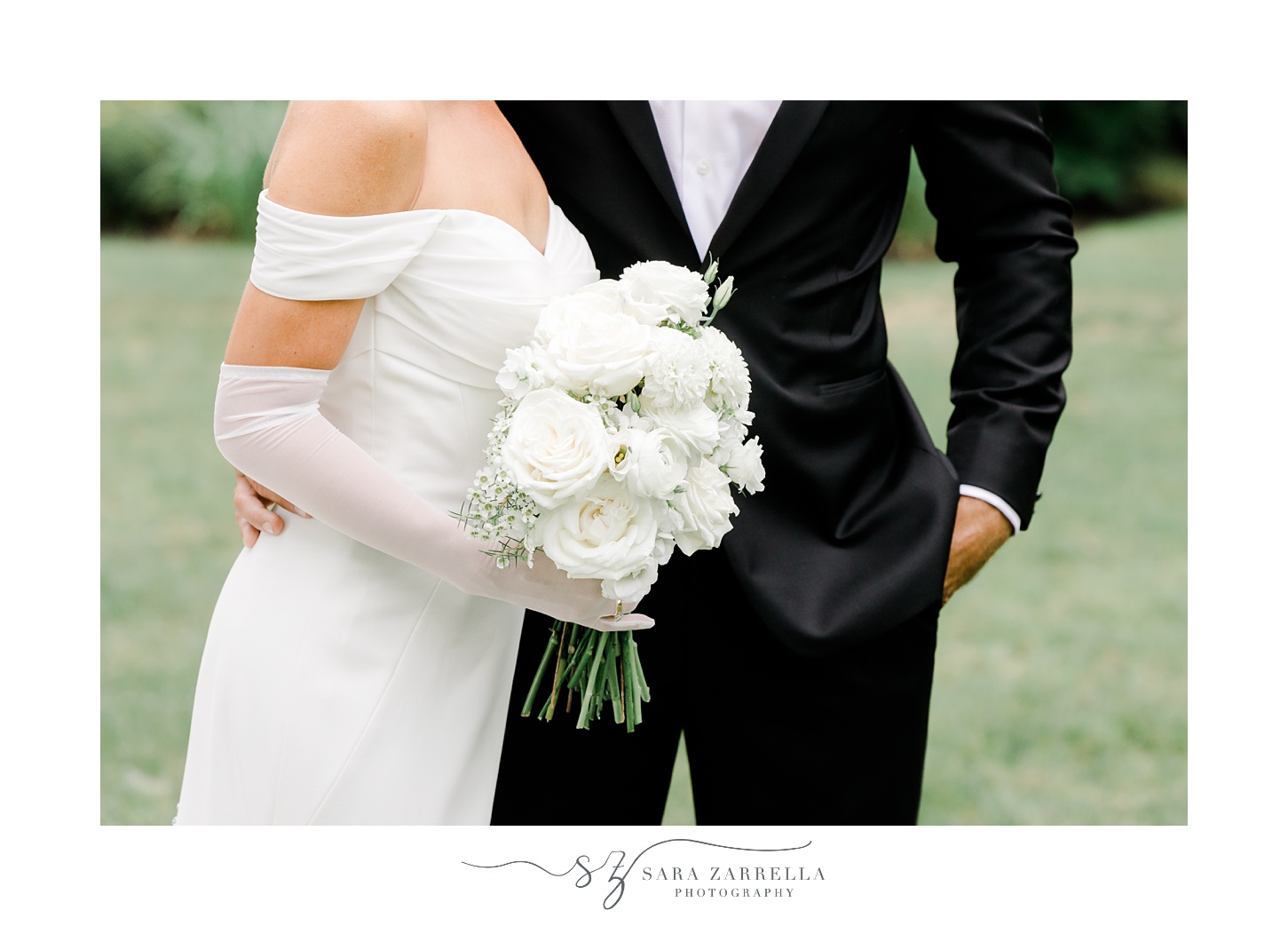 bride in white gloves in off-the-shoulder gown with Ivory bouquet hugs groom in black suit 