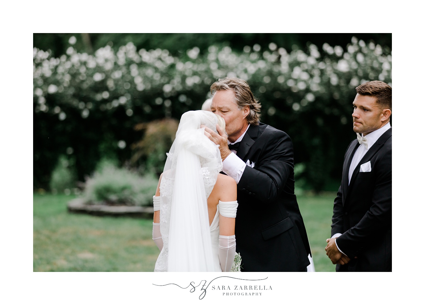 father kisses bride's forehead before wedding ceremony on lawn at Glen Manor House