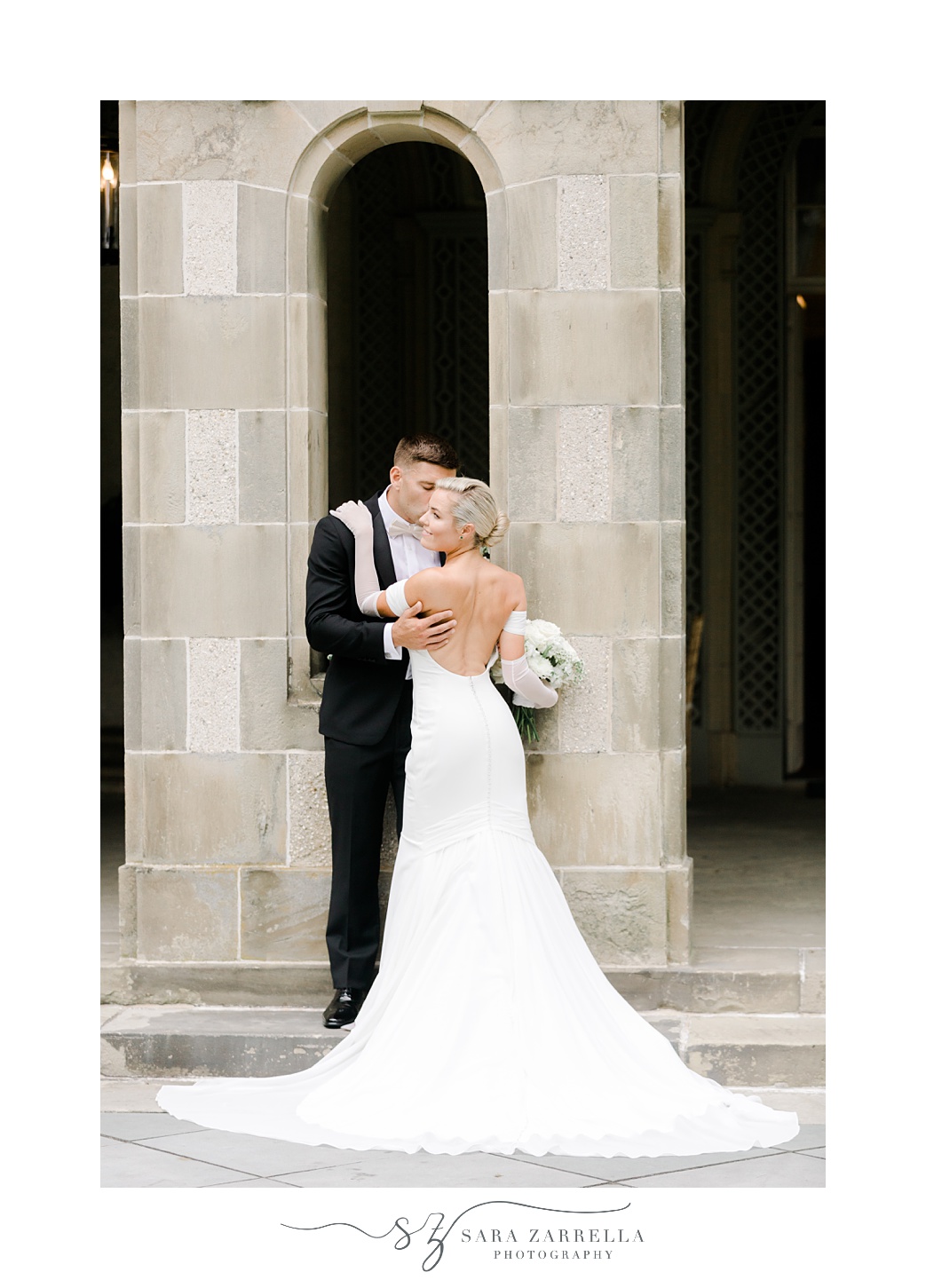 bride and groom hug between stone pillars at Glen Manor House
