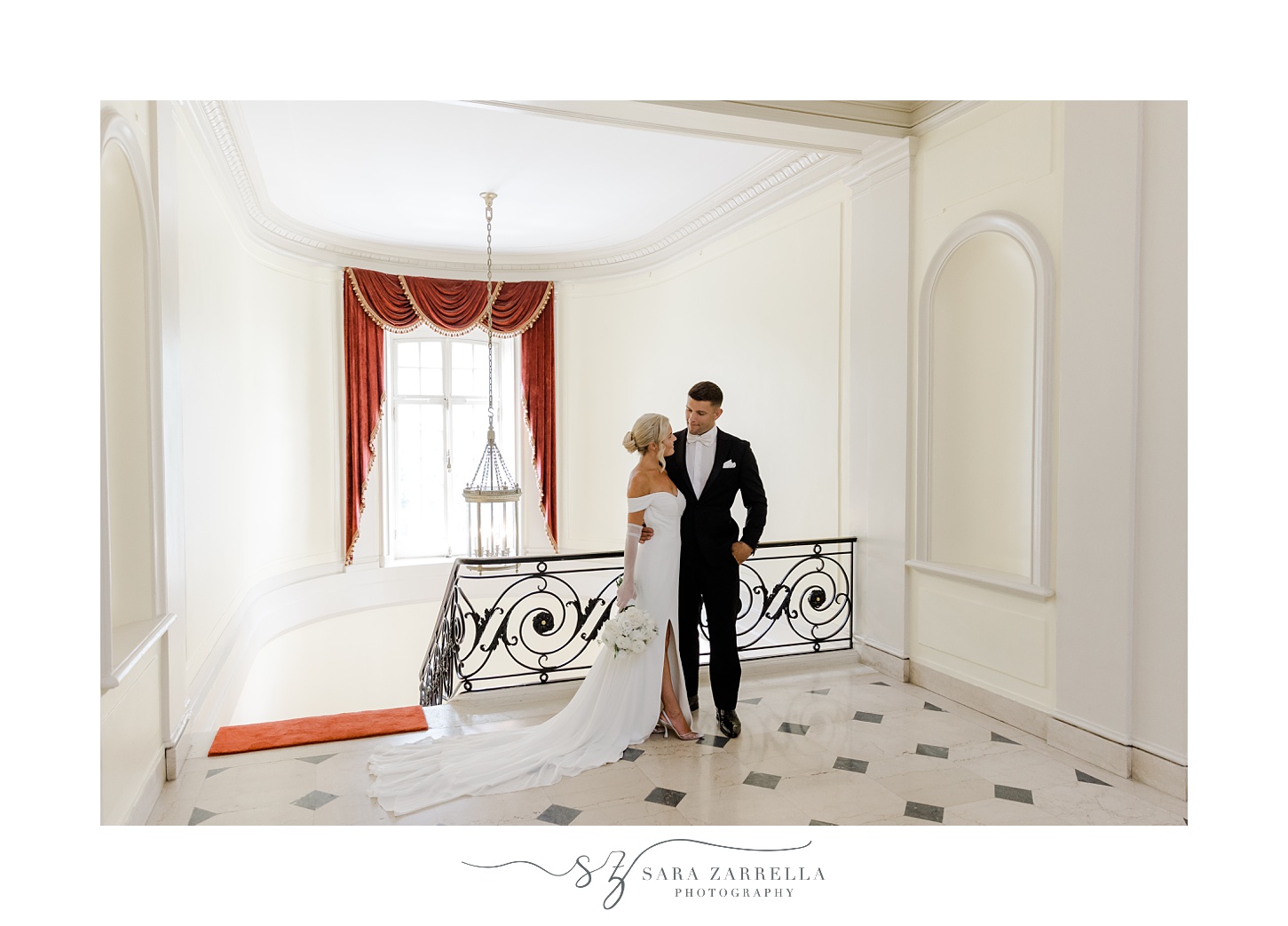 bride and groom hug inside Glen Manor House at tope of staircase with black and white floor
