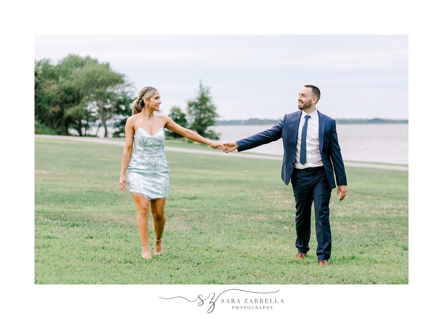 bride and groom hold hands walking on lawn of Colt State Park