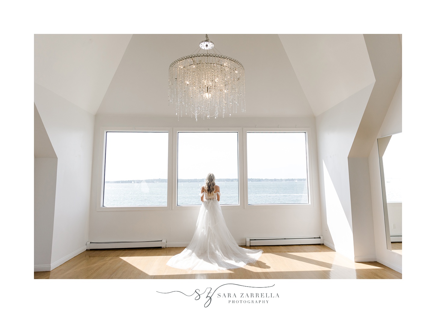 bride stands in front of large windows at Belle Mer Island House