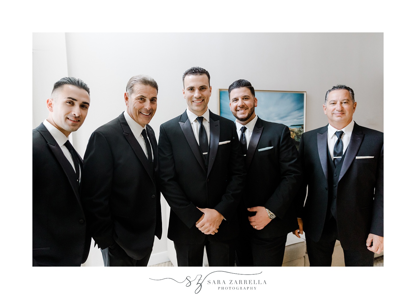groom stands with four groomsmen in black suits in Newport RI