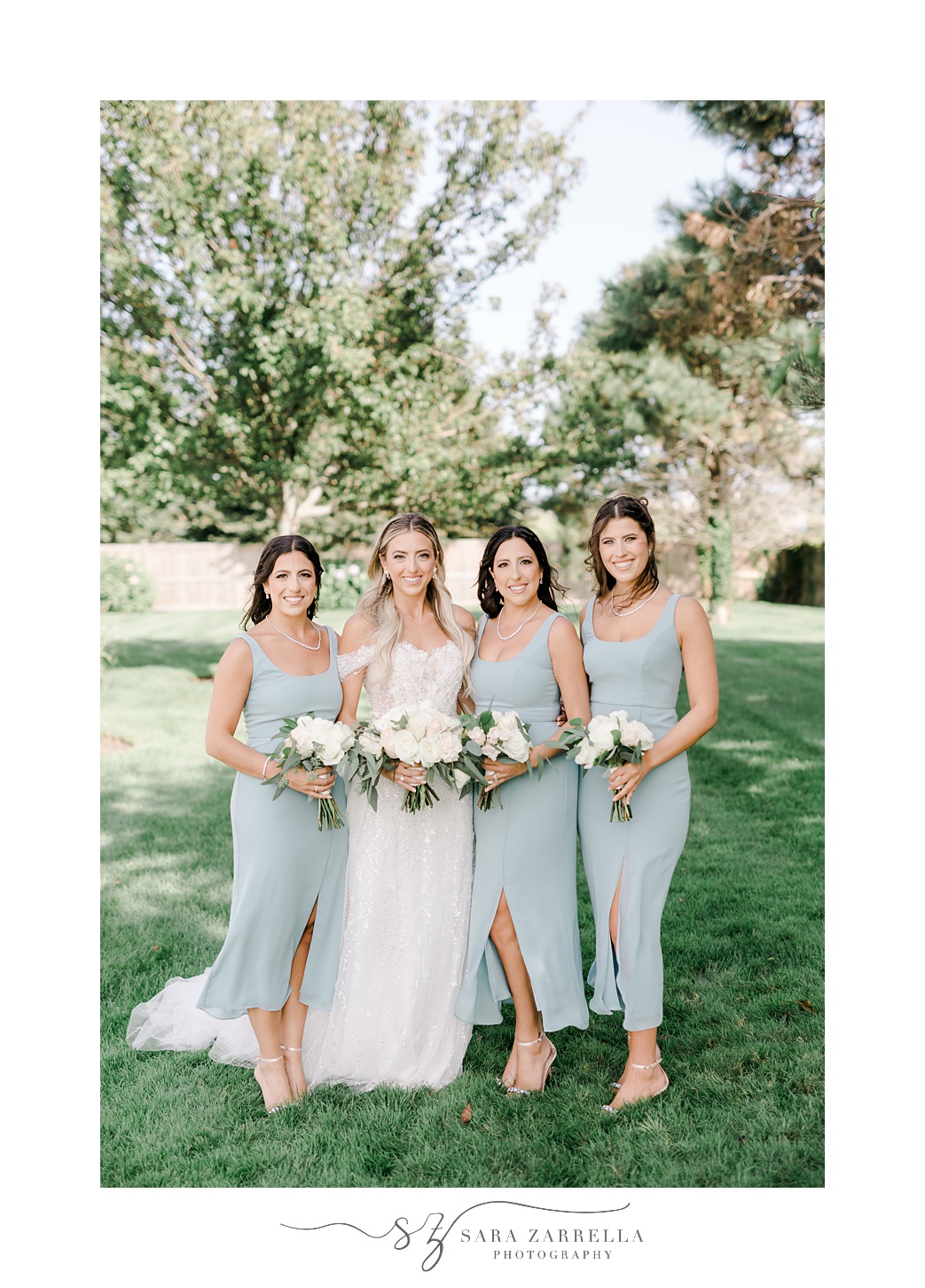 bride stands with three bridesmaids in robin's egg blue dresses 