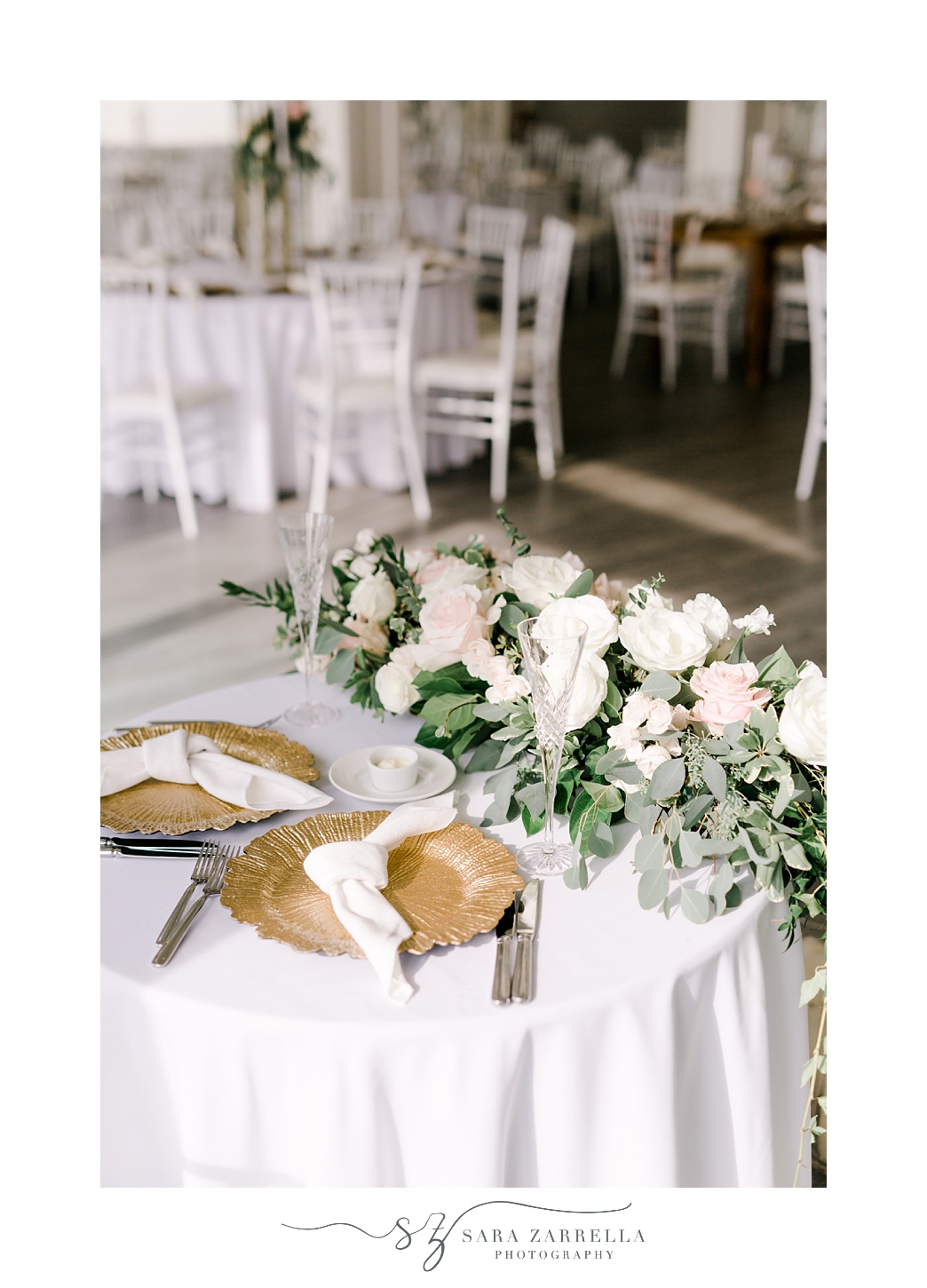 sweetheart table for summer wedding reception at Belle Mer Island House with white floral arrangement and gold chargers 