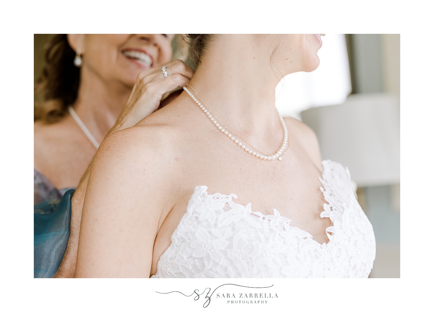 mother helps bride with pearl necklace before Rhode Island wedding day 