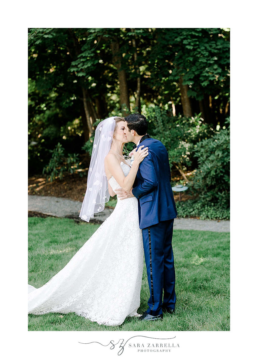 groom kisses bride dipping her slightly on lawn at the Chanler