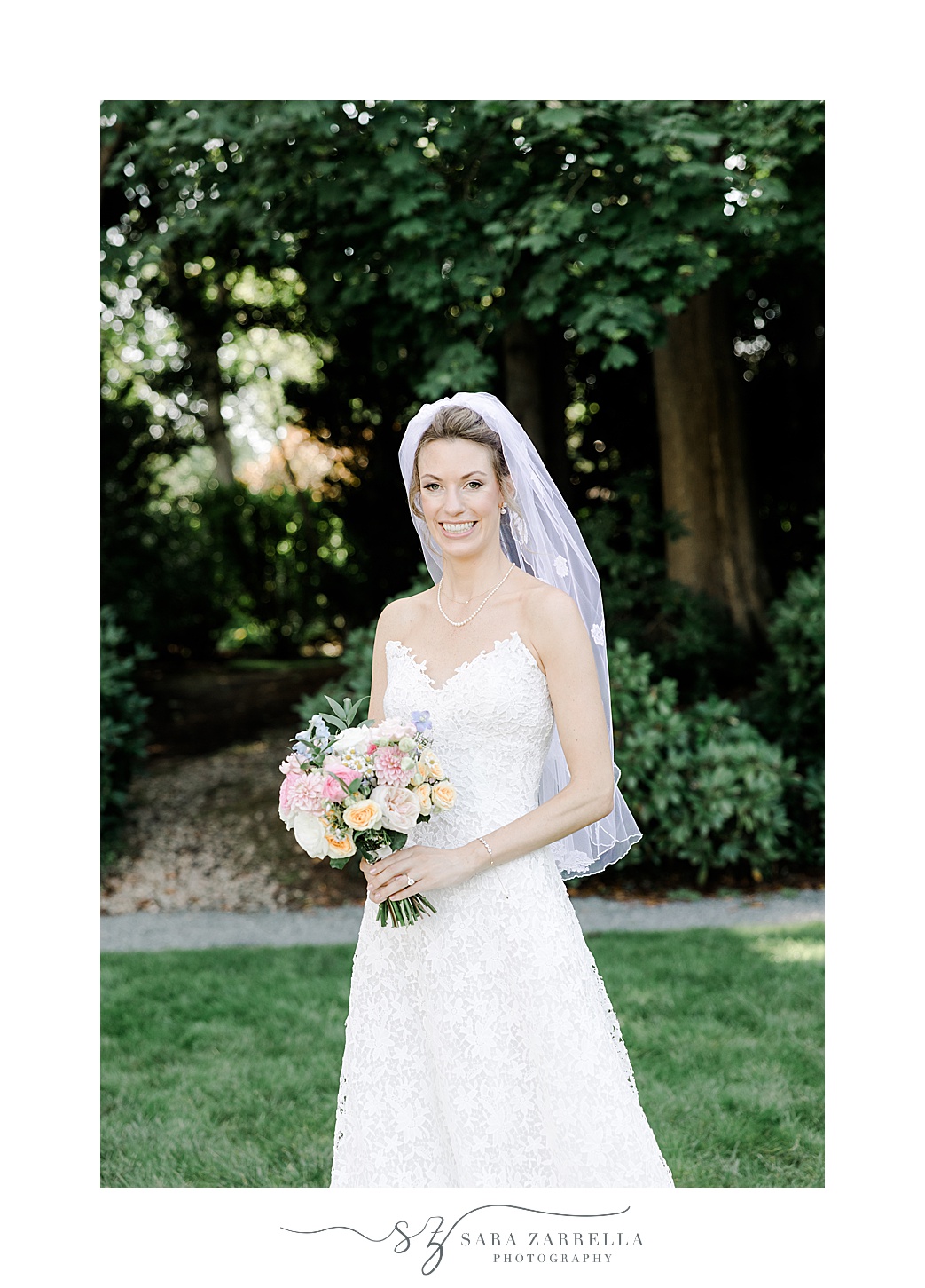 bride smiles holding colorful bouquet with short veil behind her 