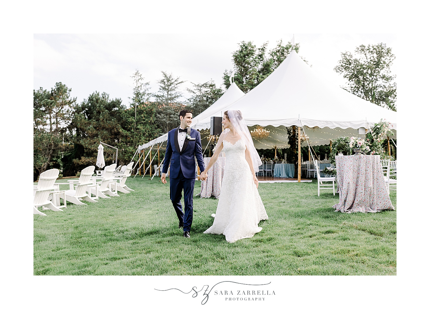 newlyweds hold hands walking near tent at the Chanler