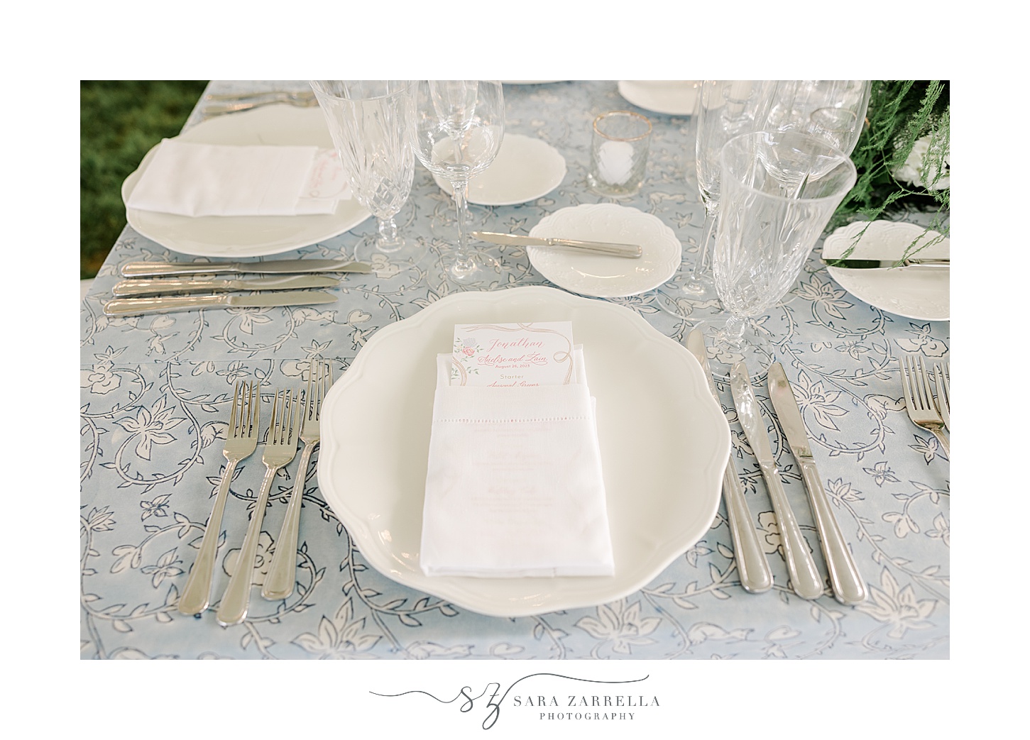 place setting with ivory plate, gold silverware and blue table cloths 