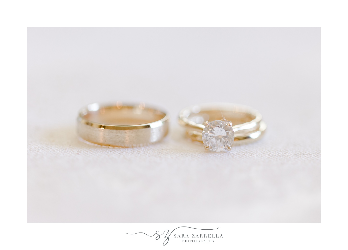 gold wedding bands lay on ivory backdrop