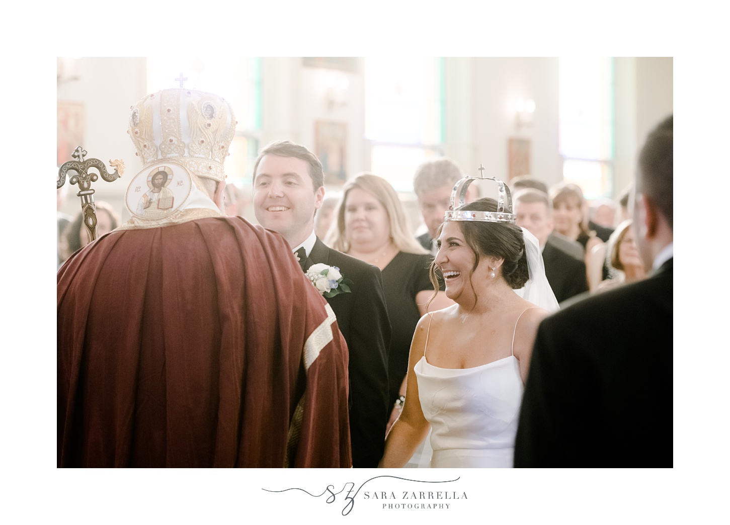 bride laughs during crowing traditional Greek Orthodox ceremony inside Saint Mary Antiochian church