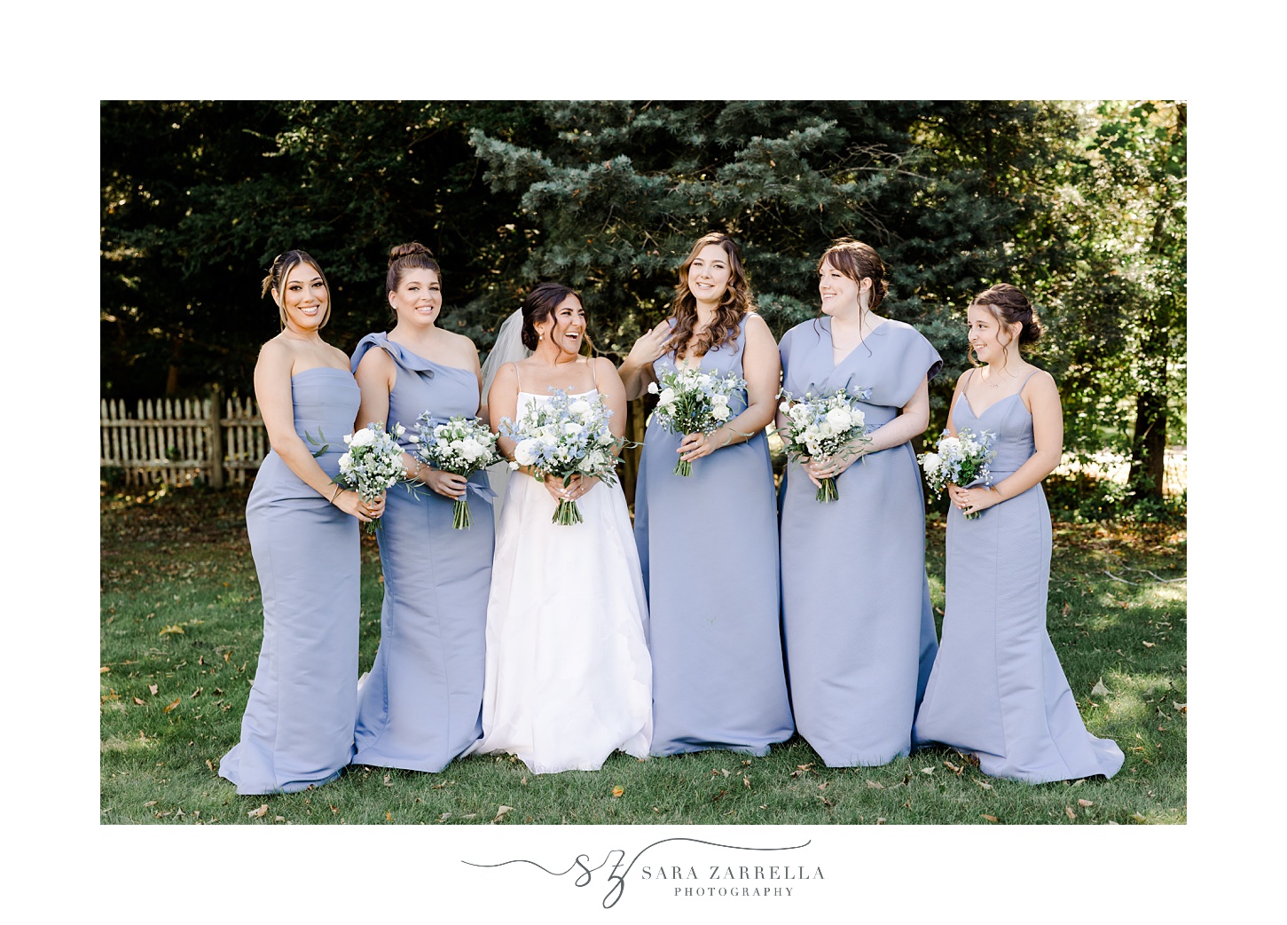 bride and bridesmaids in light blue dresses pose on lawn in Providence RI