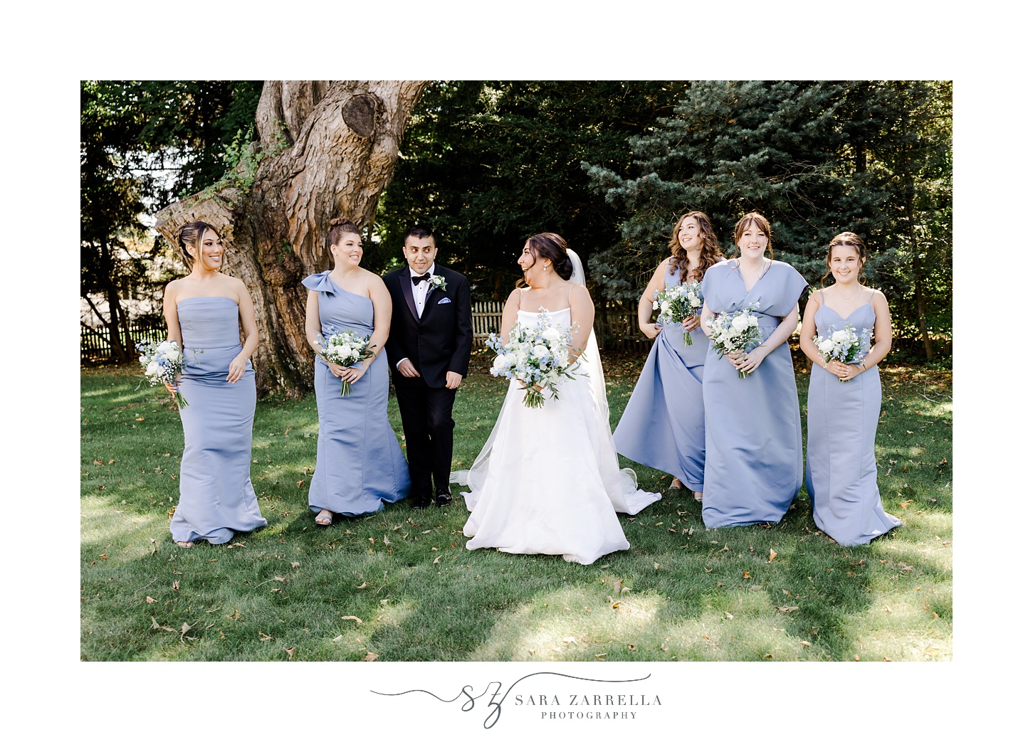 bride walks with bride's man and bridesmaids on lawn in Providence RI