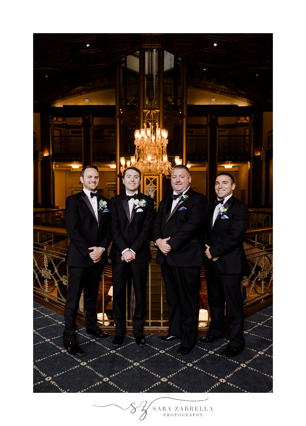 groom stands with groomsmen in lobby of the Graduate Providence