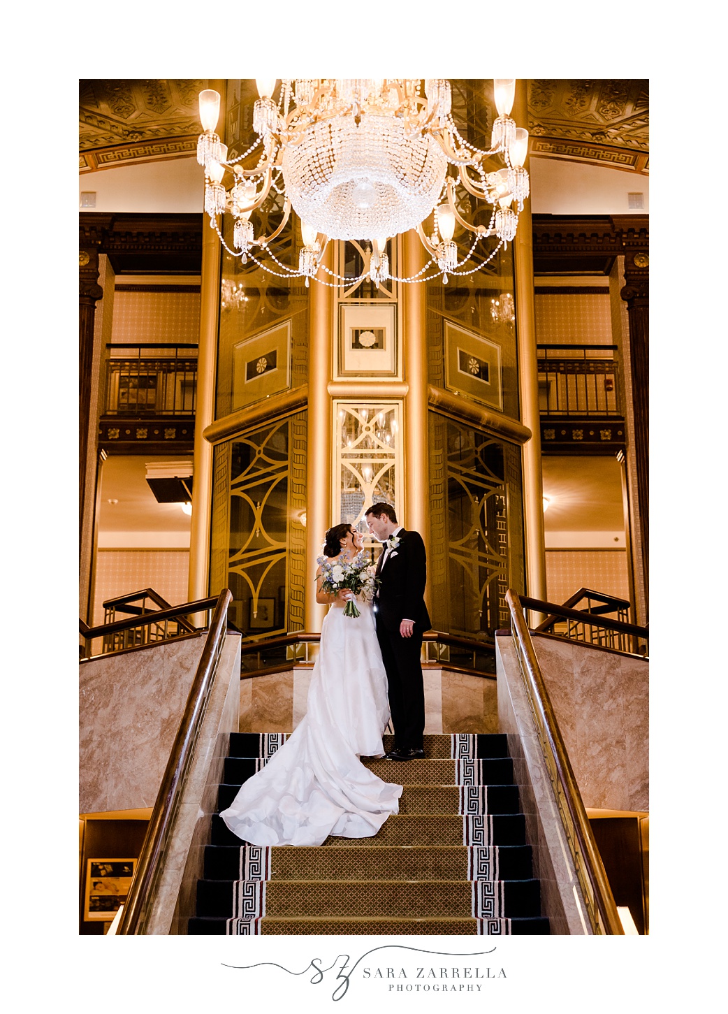 newlyweds pose on staircase inside the Graduate Providence