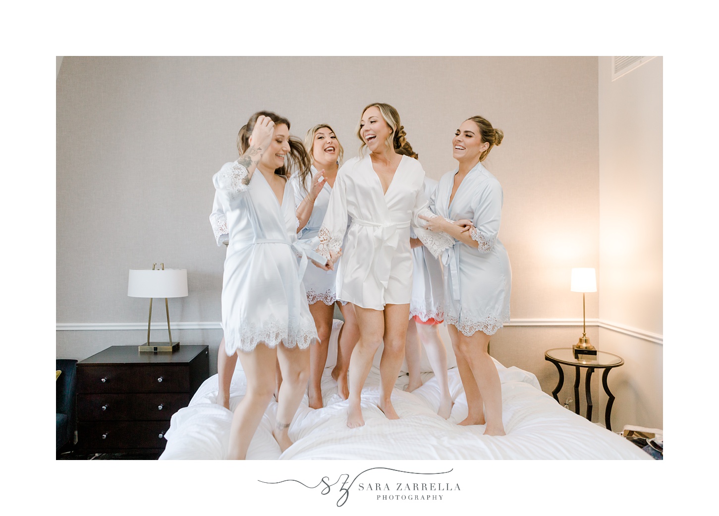 bride and bridesmaids dance on bed in Newport RI
