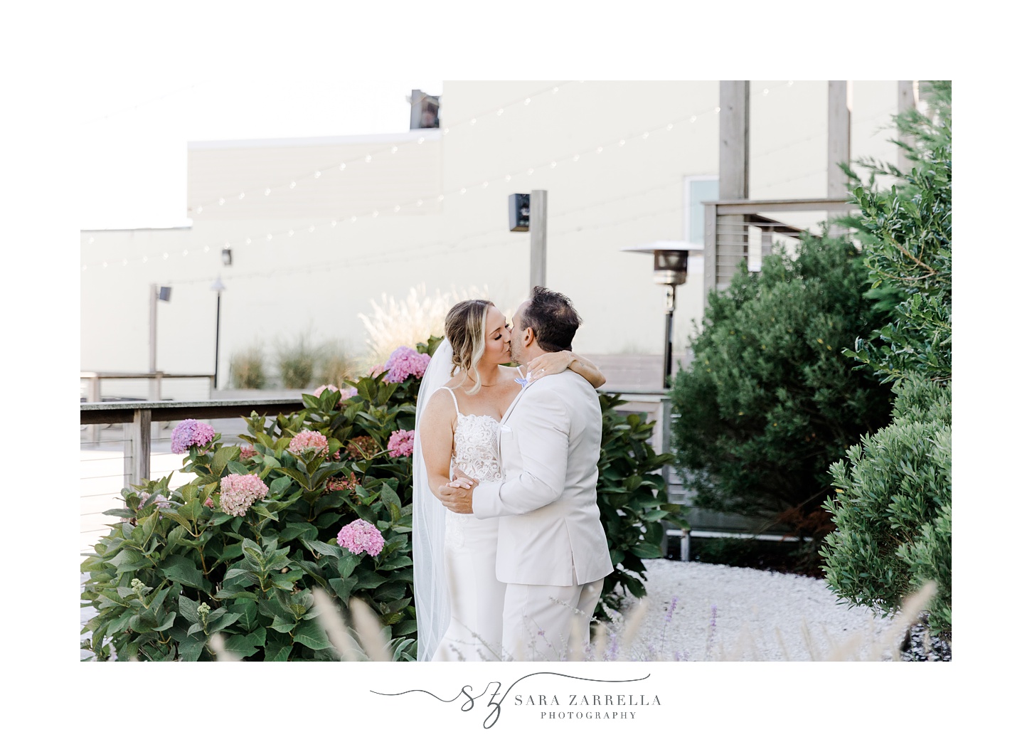 newlyweds hug kissing by Regatta Place in Newport RI