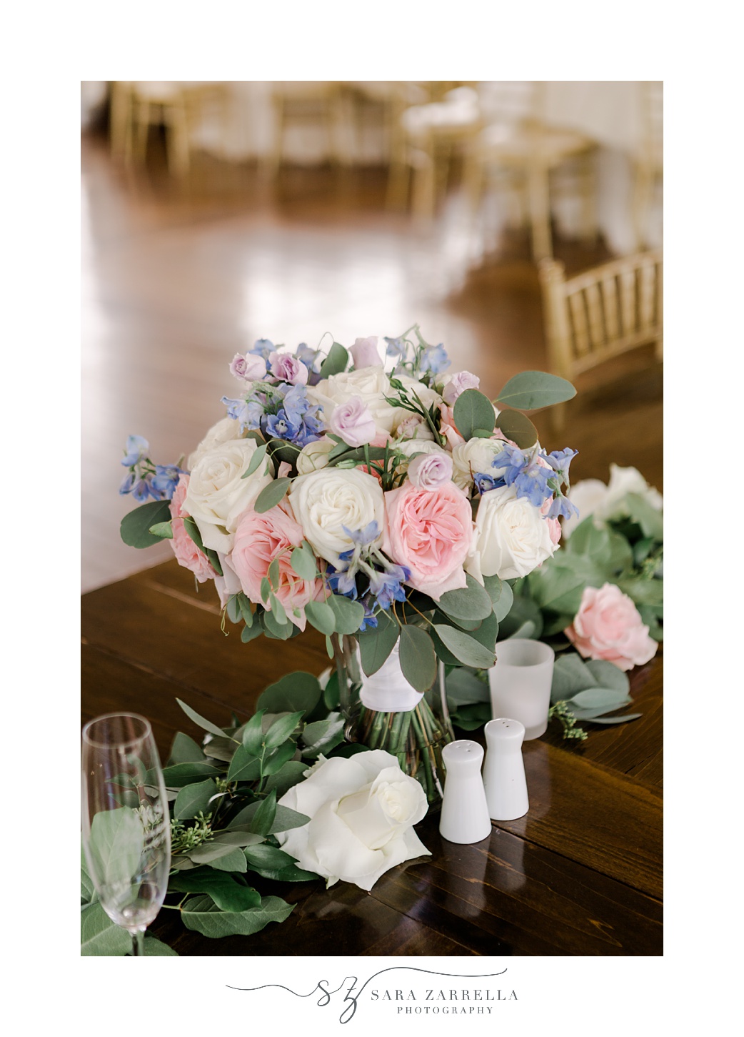 pink, white, and blue flowers sit on wooden table at Regatta Place