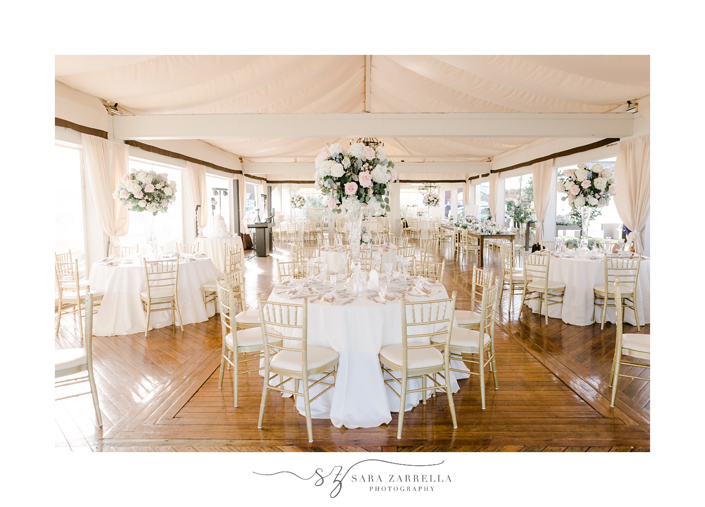 tented wedding reception at Regatta Place with pink and white flowers with gold chairs 