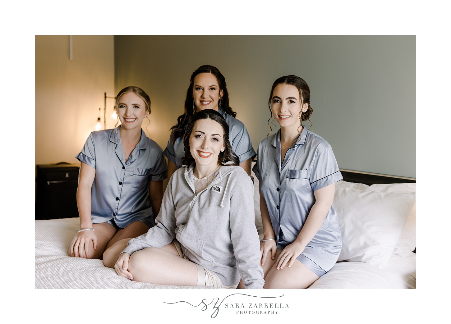 bride sits on bed with bridesmaids at the Atlantic Wyndham Resort