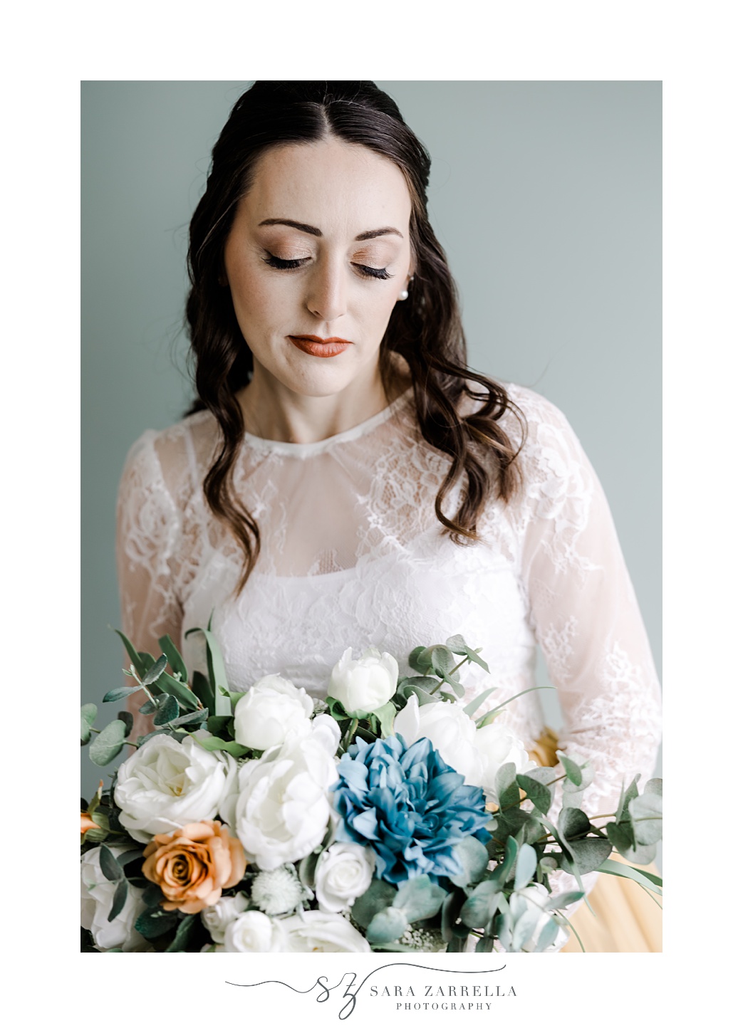 bride with lace top looks down at bouquet of silk flowers at the Atlantic Wyndham Resort