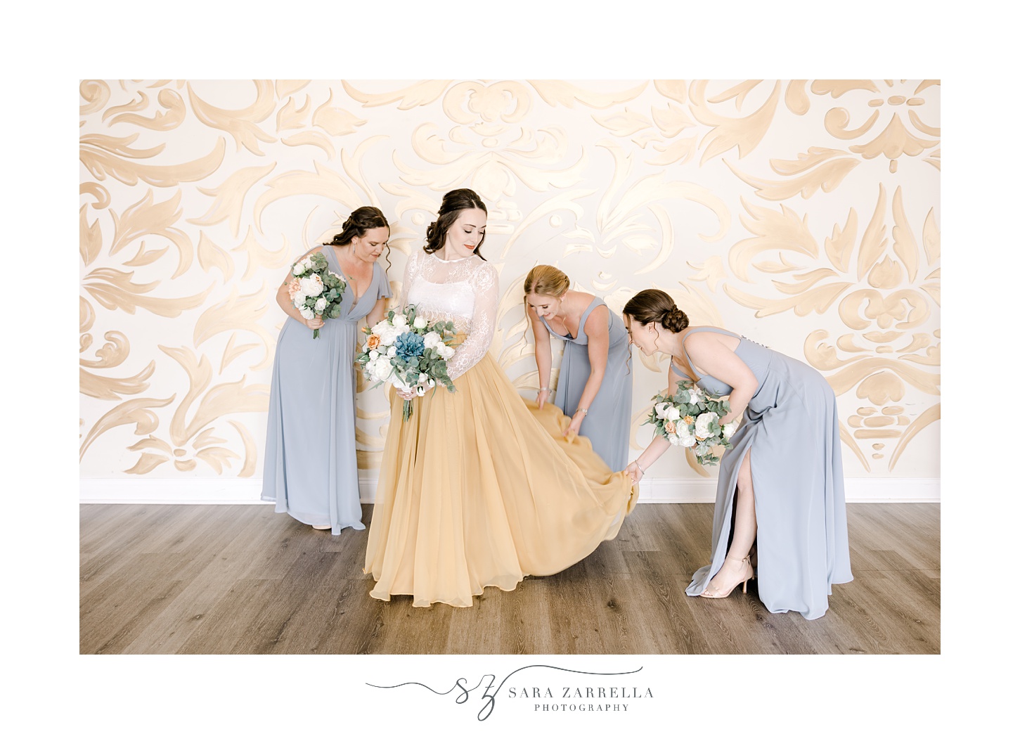 bridesmaids in blue gowns help bride with skirt of wedding gown