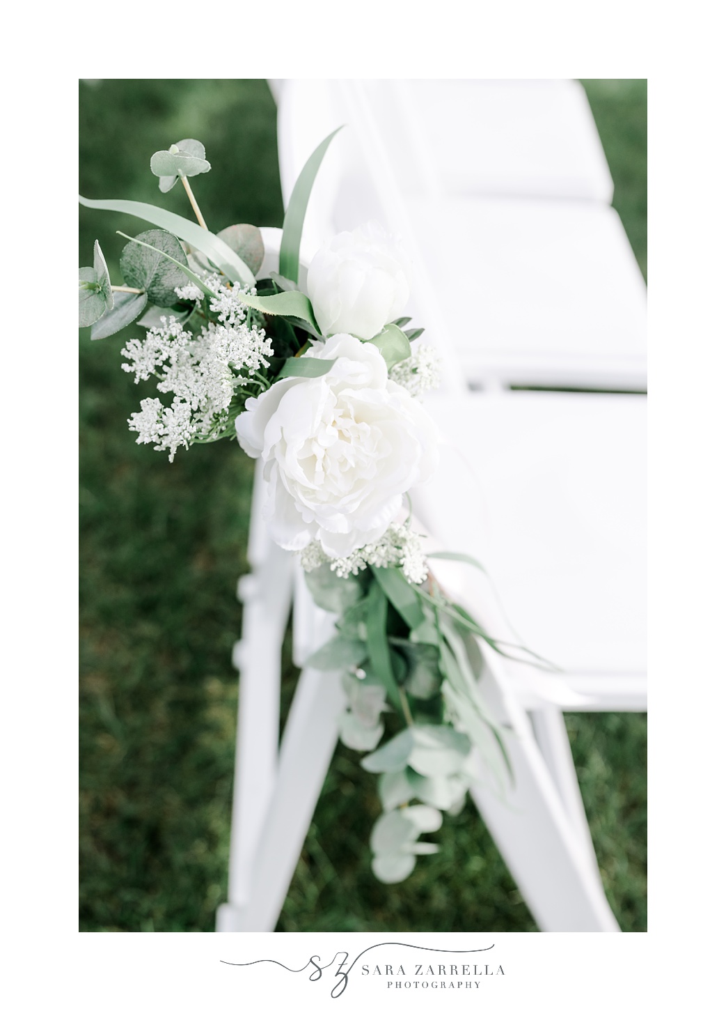 white roses hang on white chairs for outdoor wedding ceremony at the Atlantic Wyndham Resort
