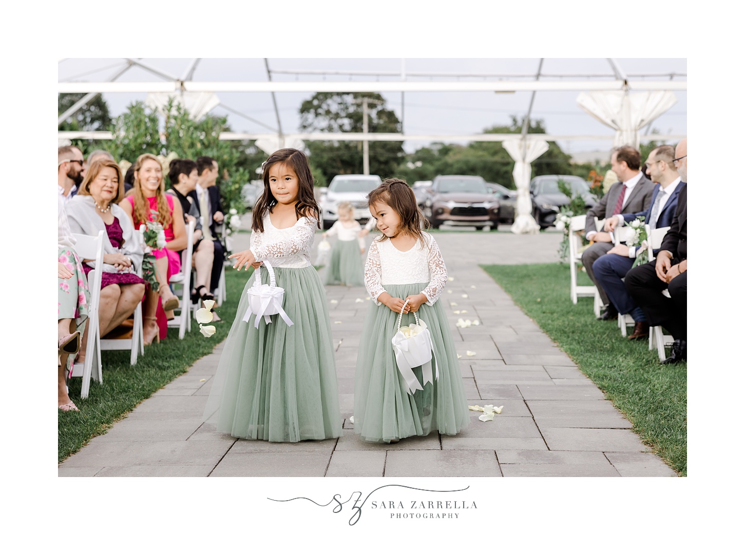 flower girls in white and green dresses walk down aisle for outdoor wedding ceremony at the Atlantic Wyndham Resort