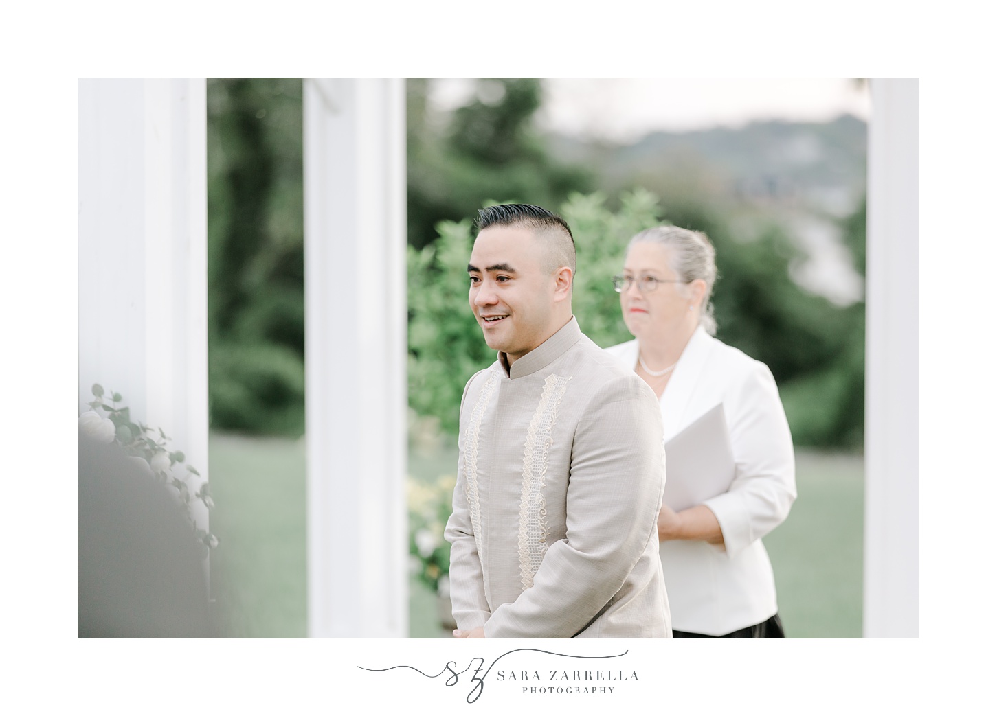 groom in gold and white barong shirt smiles watching bride 
