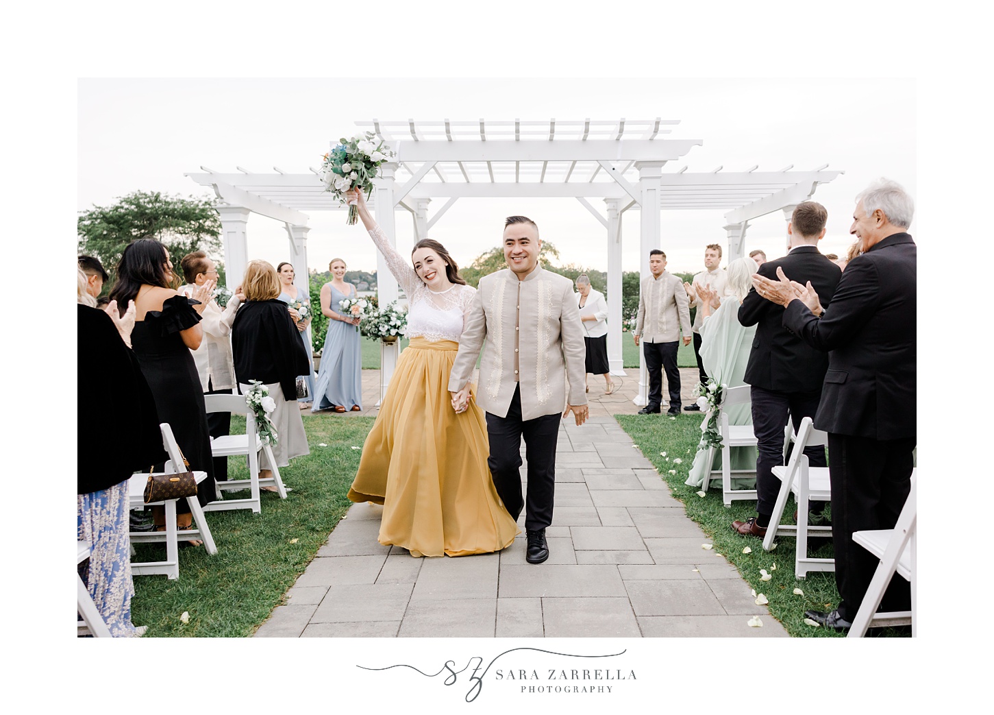 bride cheers with groom walking up aisle after outdoor wedding ceremony at the Atlantic Wyndham Resort