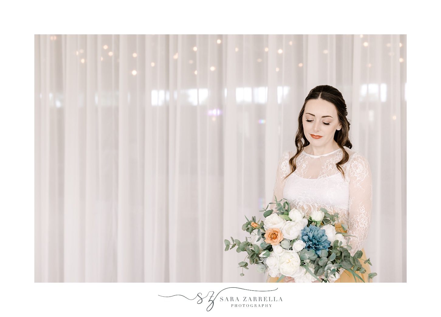 brunette woman looks at bouquet of white, blue, and orange flowers 
