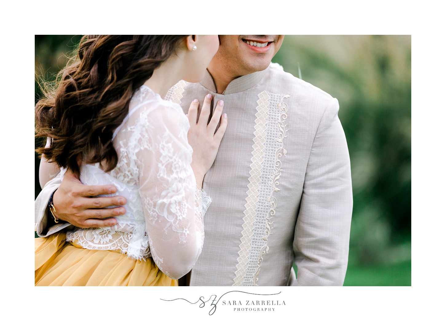 bride leans into groom's chest laying hand on his barong style shirt 