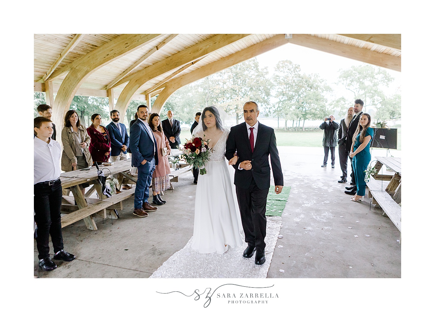 bride and father walk up aisle at the Chapel by the Sea in Colt State Park
