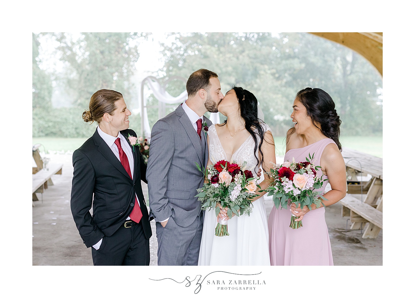 newlyweds kiss during wedding portraits with bridal party 