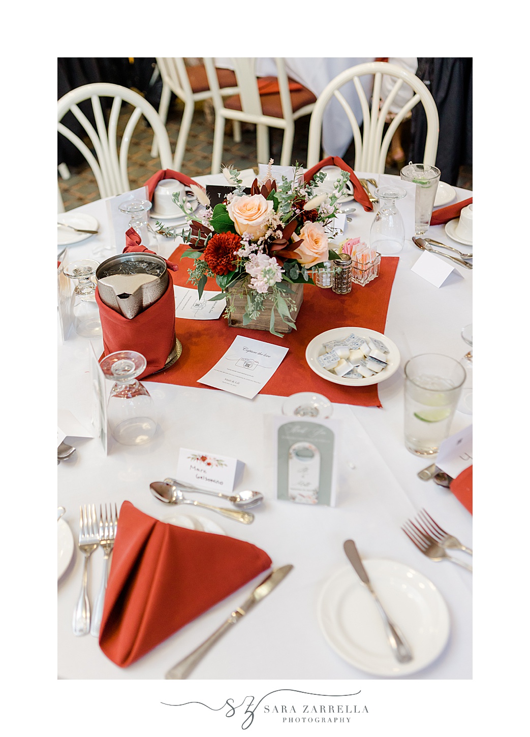 place setting at Jacky's Galaxie with red napkins and pink flowers in center of table 