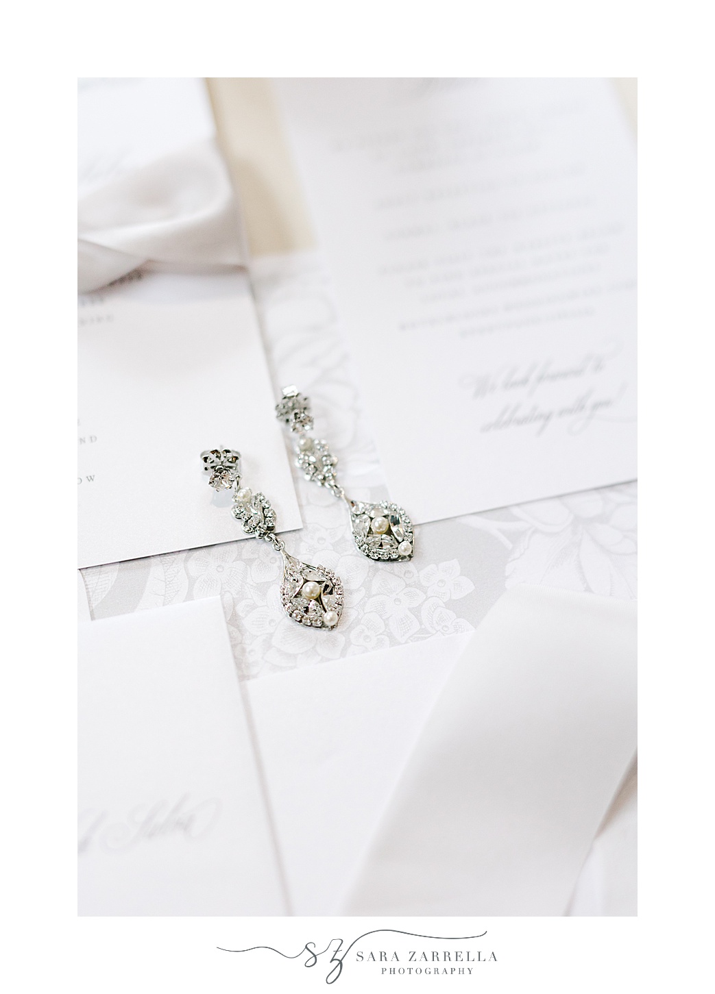 diamond earrings rest on invitation suite at Rosecliff Mansion