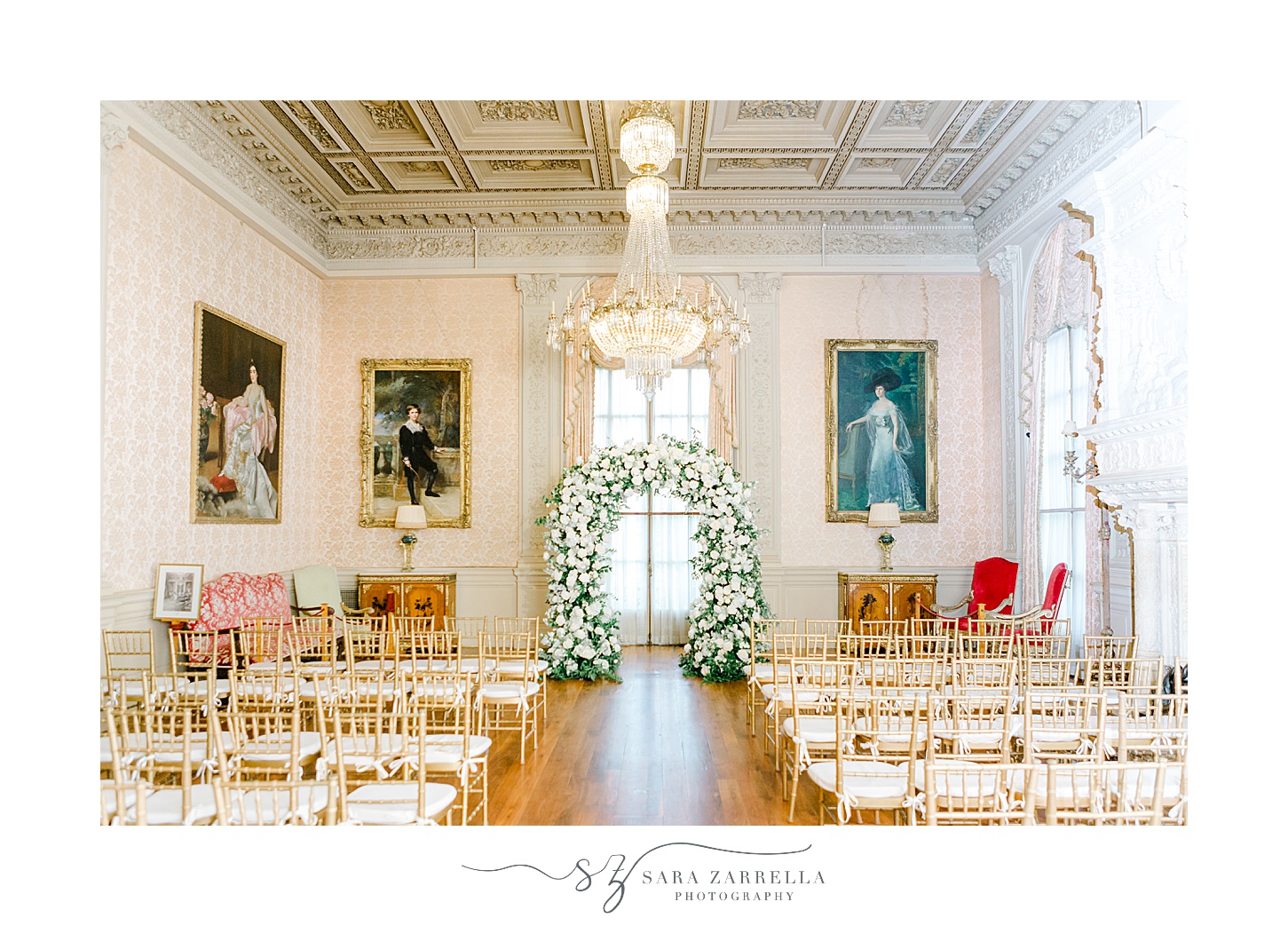 wedding ceremony with white and green arbor inside Rosecliff Mansion