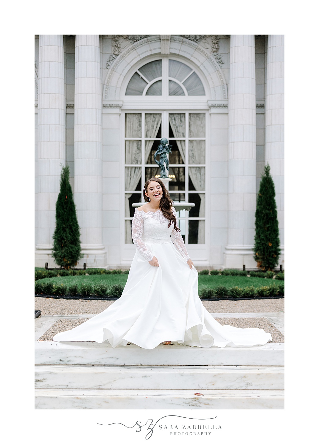 bride twirls in wedding gown with lace sleeves outside Rosecliff Mansion