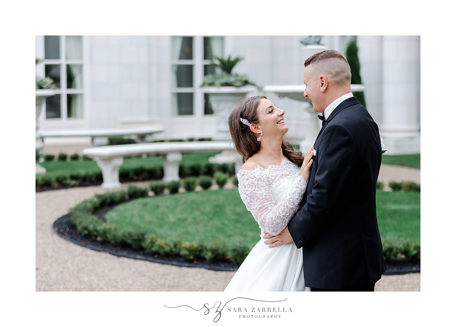 newlyweds pose by greenery in garden at Rosecliff Mansion