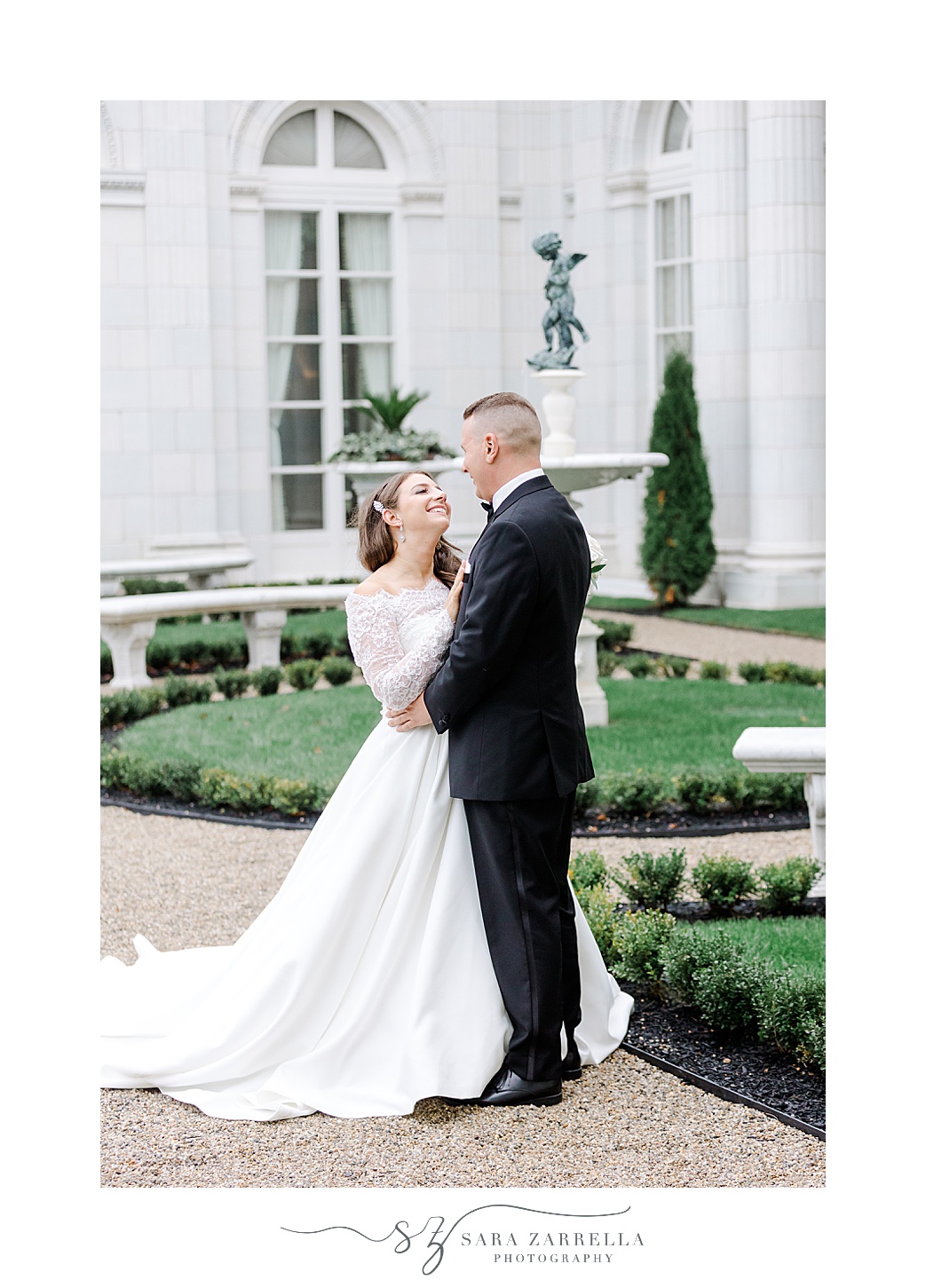 newlyweds hug in gardens outside Rosecliff Mansion