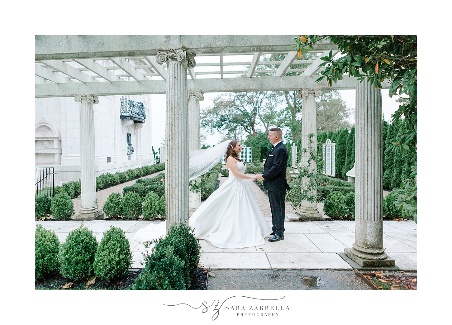 bride and groom walk under stone arbor in RoseCliff Mansion